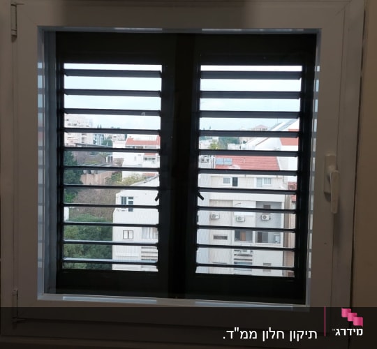 תריסים אופקיים פתוחים בחלון לבן
